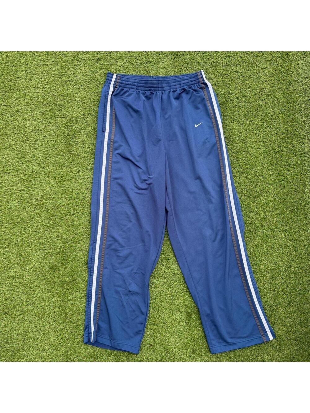 Vintage Nike track pants in navy with white and grey side stripes. Classic Y2K